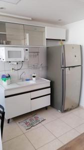 a kitchen with a refrigerator and a sink at Apto perto do Hotel Premium com garagem, 3 camas, 2 quartos, portaria 24h in Campinas