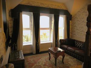 a living room with a couch and two windows at Albany Lodge in Portrush