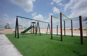 un parco giochi vuoto con altalena sul prato di Léo's Cachette a Naga