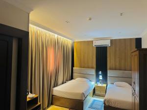 a hotel room with two beds and a window at Al Saraya Hotel Bani Sweif in Banī ‘Aţīyah +80 photos