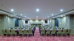 une salle de conférence avec une table, des chaises et une scène dans l'établissement de Laxston Hotel Jogja by AZANA, à Yogyakarta