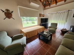 - un salon avec un lit, des chaises et une table dans l'établissement Casa quinta en Brandsen, à Brandsen