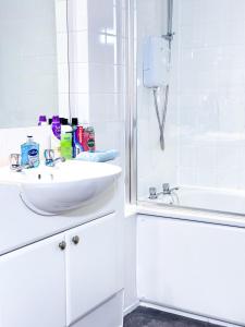 a white bathroom with a sink and a shower at Glasgow City Centre Stylish Flat in Glasgow
