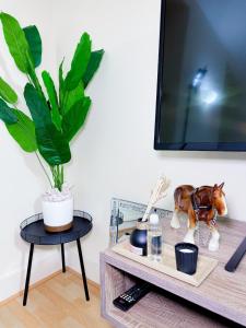 a living room with a tv and a table at Glasgow City Centre Stylish Flat in Glasgow