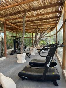 una palestra con tapis roulant e alberi sullo sfondo di Kuunaa Tulum I Beer Sanctuary & Spa a Tulum