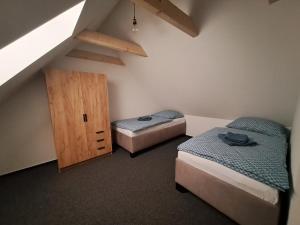 a room with two beds and a wooden cabinet at Apartmán Drevenica in Párnica