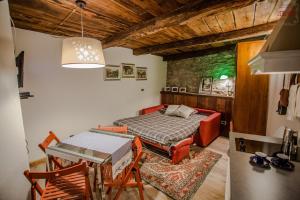 a room with a bed and a table and a refrigerator at Piccolo Rifugio - Alpine Studio flat Valtournenche in Valtournenche