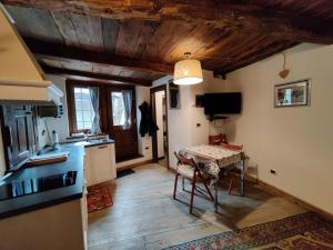 a kitchen with a table in the middle of a room at Piccolo Rifugio - Alpine Studio flat Valtournenche in Valtournenche