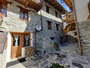 an exterior view of a stone building with a wooden door at Piccolo Rifugio - Alpine Studio flat Valtournenche in Valtournenche