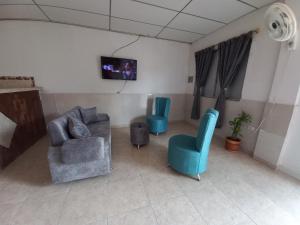 a living room with two chairs and a tv at Apartamento Jarhel in Aguachica