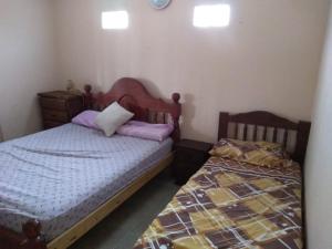 two beds in a small room withermottermottermott at Nuevo Amanecer in Villa Los Aromos +22 photos