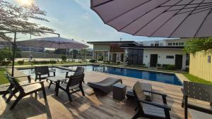 a patio with chairs and an umbrella and a pool at Near Mactan Airport, Pool, Fast WiFi, Netflix & Disney in Lapu Lapu City