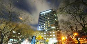 a tall building with lights on top at night at Hyundai Residence in Seoul