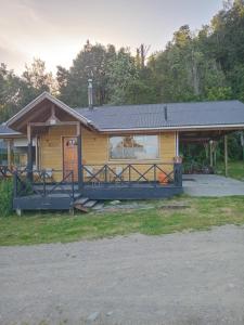 a small yellow house with a porch at El Avellano in Frutillar