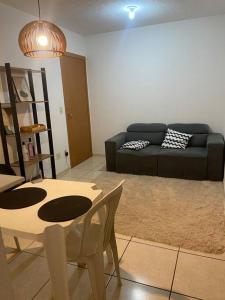 ein Wohnzimmer mit Sofa, Tisch und Stühlen in der Unterkunft Apto aconchegante a 3km da orla in Lagoa Santa