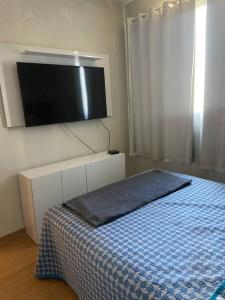 ein Schlafzimmer mit Bett und Flachbildfernseher in der Unterkunft Apto aconchegante a 3km da orla in Lagoa Santa