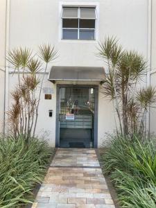 eine Tür zu einem Gebäude mit Fenster und Pflanzen in der Unterkunft Apto aconchegante a 3km da orla in Lagoa Santa