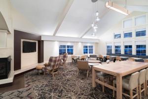 a large room with tables and chairs and a fireplace at Residence Inn Southington in Southington