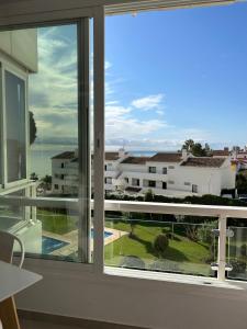 pokój z oknem z widokiem na budynek w obiekcie Cisnes Benalmádena Beach w mieście Benalmádena