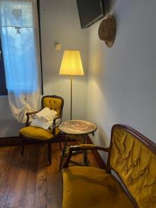 a living room with a table and chairs and a lamp at Agriturismo Rio Verde in Sasso Marconi