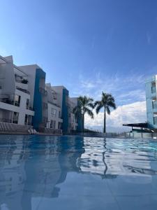 a swimming pool with palm trees and buildings at Hakuna Matata in San Jerónimo