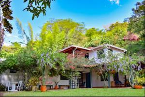 a house with flowering trees in front of it at Espectacular finca Familiar en sopetran Antioquia in Sopetran