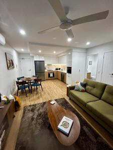a living room with a green couch and a table at Chermside Central Apartment in Brisbane