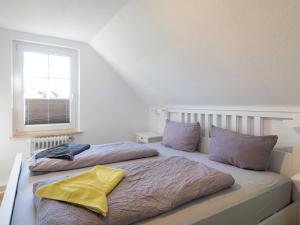 a bedroom with two beds and a window at Huus unner Lee 3 in Spiekeroog