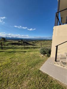 a view of a field next to a building at Mirada al Champaquí - Chalet de Montaña in Villa Yacanto +76 photos