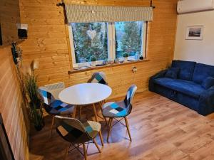 a living room with a table and chairs and a couch at Tysiowa Chata in Mchawa