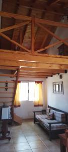 a large room with a bed and a wooden ceiling at Cabañas El Duende in Quines
