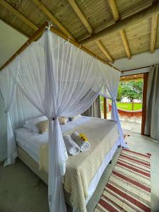 塞古罗港Casa sereníssima的卧室里有一张带白色窗帘的四柱床