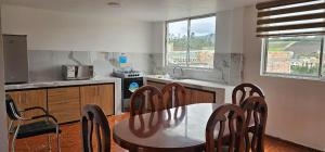 a kitchen with a table and chairs in a room at Departamentos La Frontera in Tulcán