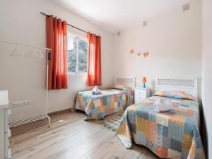 2 camas en un dormitorio con cortinas rojas en Holiday Home in Garachico with Mountain Views, en Genovés