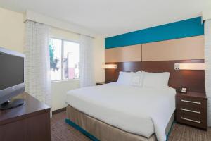a bedroom with a bed and a flat screen tv at Residence Inn Bakersfield in Bakersfield +18 photos