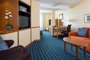 a hotel room with a couch and a table and a tv at Fairfield Inn & Suites Valparaiso in Valparaiso