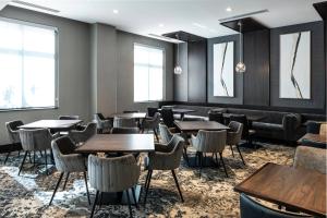 a dining room with tables and chairs and windows at Residence Inn by Marriott Boston Logan Airport/Chelsea in Chelsea