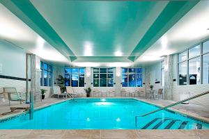 a swimming pool in a building with a large ceiling at Residence Inn by Marriott Boston Logan Airport/Chelsea in Chelsea
