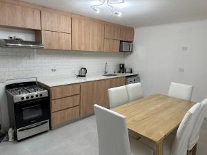 a kitchen with a wooden table and a table and chairs at Casa a Estrenar - Monte Hermoso in Monte Hermoso