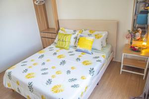 a small bedroom with a bed with yellow pillows at CDO Spacious 1 BR Corner Condo in front of Limketkai Mall in Cagayan de Oro