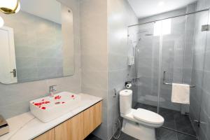 a bathroom with a sink and a toilet and a shower at TN Hue Dorm in Hue