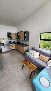 a living room with a couch and a kitchen at Sunny 2-bed condo - fast WIFI in Puntarenas