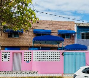 a pink and blue fence in front of a building at Guest House Rosa do Mar in Olinda