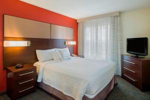 a hotel room with a bed and a flat screen tv at Residence Inn Boston Framingham in Framingham +13 photos