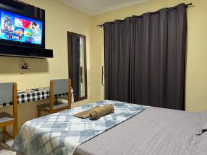 a bedroom with a bed with a pillow on it at Capim de Ouro Flats Mobiliados in Palmas