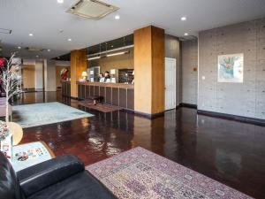 a living room with a couch and a bar at Hotel Fujiyoshi in Beppu