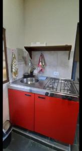 a kitchen with a red stove and a sink at Chales Arco-iris 2 - Para quem procura simplicidade em uma ótima localização in Ilhabela