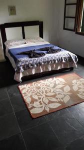 une chambre avec un lit avec un tapis sur le sol dans l'établissement Casa das pedras, à Teresópolis