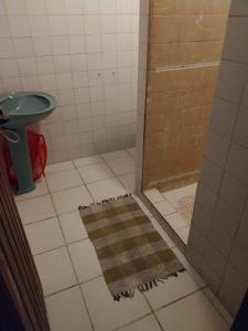 La salle de bains est pourvue d'une douche, d'un tapis et d'un lavabo. dans l'établissement Casa das pedras, à Teresópolis