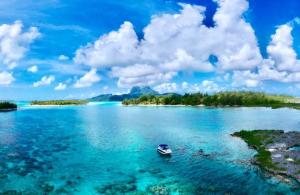a boat in the water near an island at Sunset Hill Lodge in Bora Bora